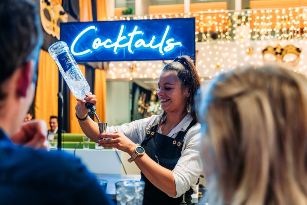 Lachende bartender met cocktailbar op locatie